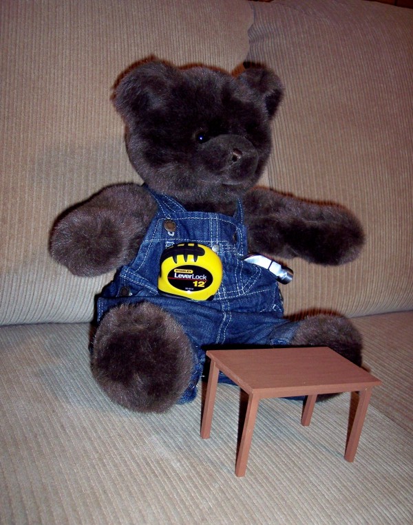 photo of a small table with a teddy bear sitting on it.